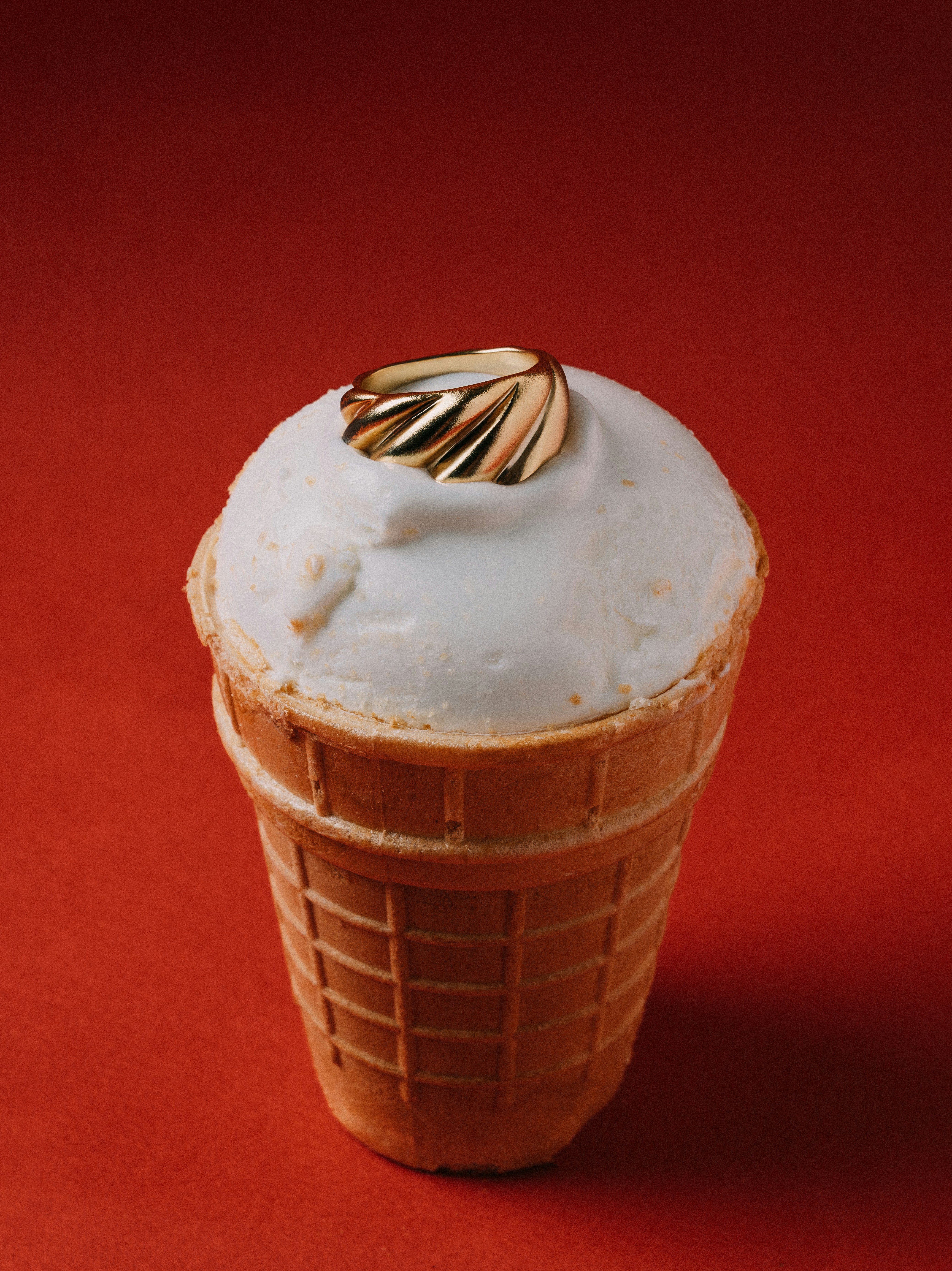 Un cono gelato con un anello d'oro in cima