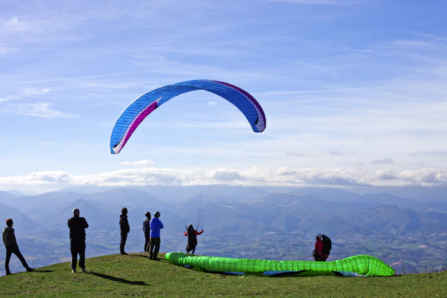 A group of people standing on top of a lush green hillside