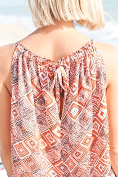 A woman standing on the beach with her back to the camera