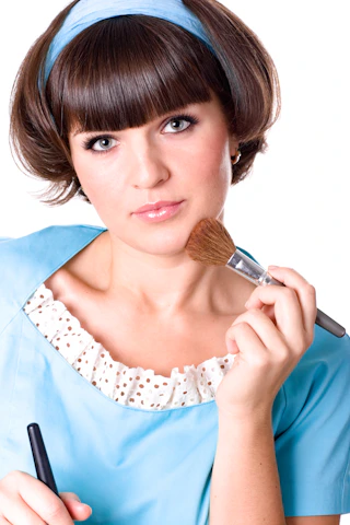 A woman in a blue dress is holding a brush