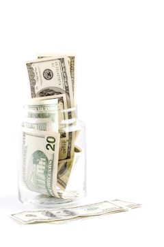 A glass jar getting filled with money. 