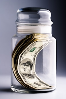 A jar filled with money sitting on top of a table