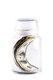 A jar filled with money sitting on top of a table