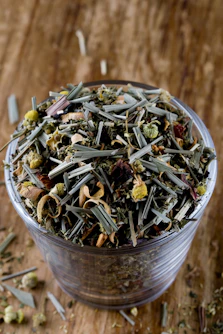 A cup filled with green tea sitting on top of a wooden table