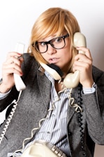 A woman holding a telephone up to her ear