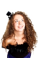 A woman with curly hair wearing a blue dress