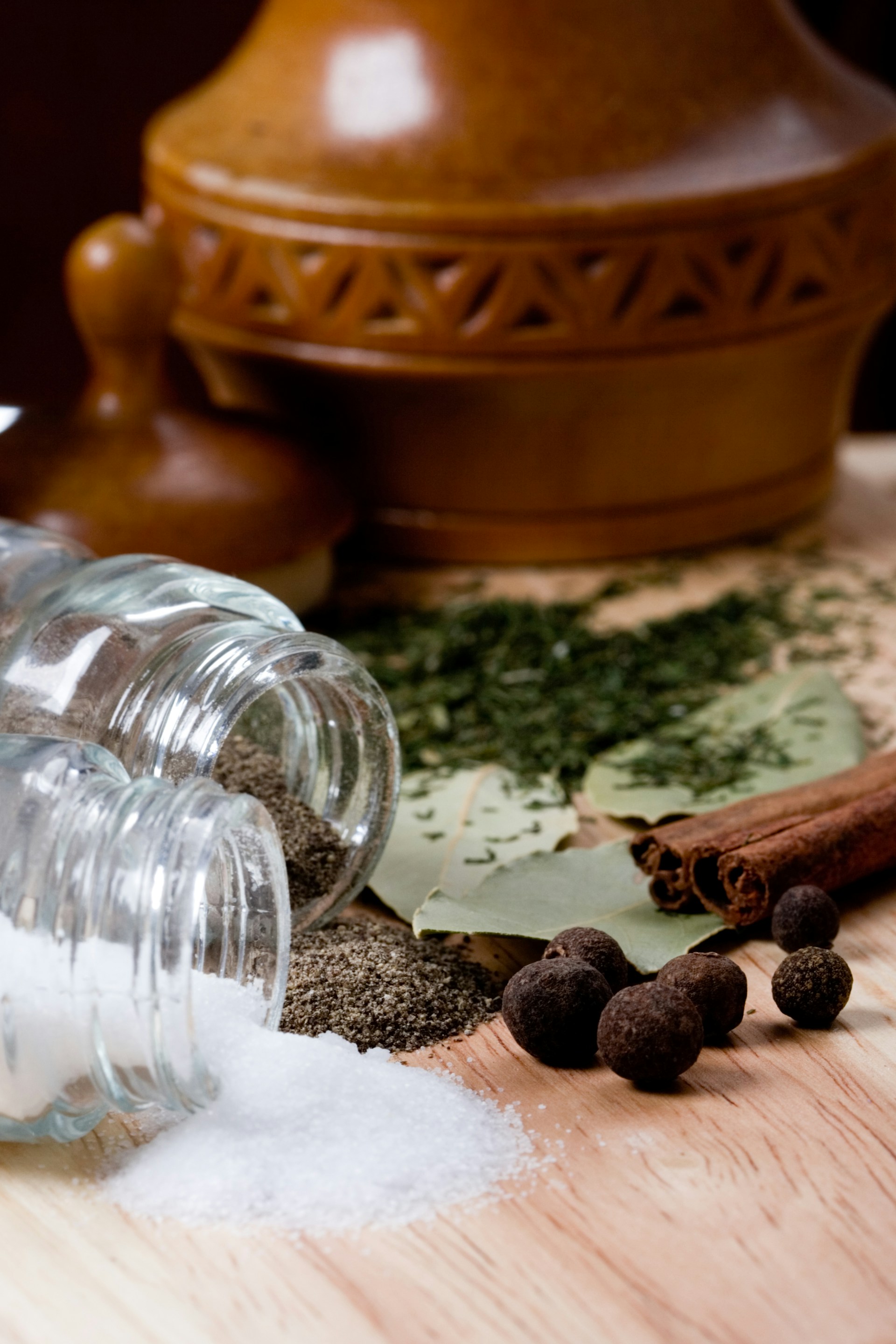 A wooden table topped with bottles filled with spices
