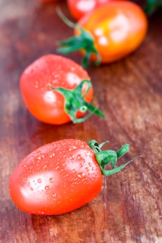 A close up of three tomatoes on a table