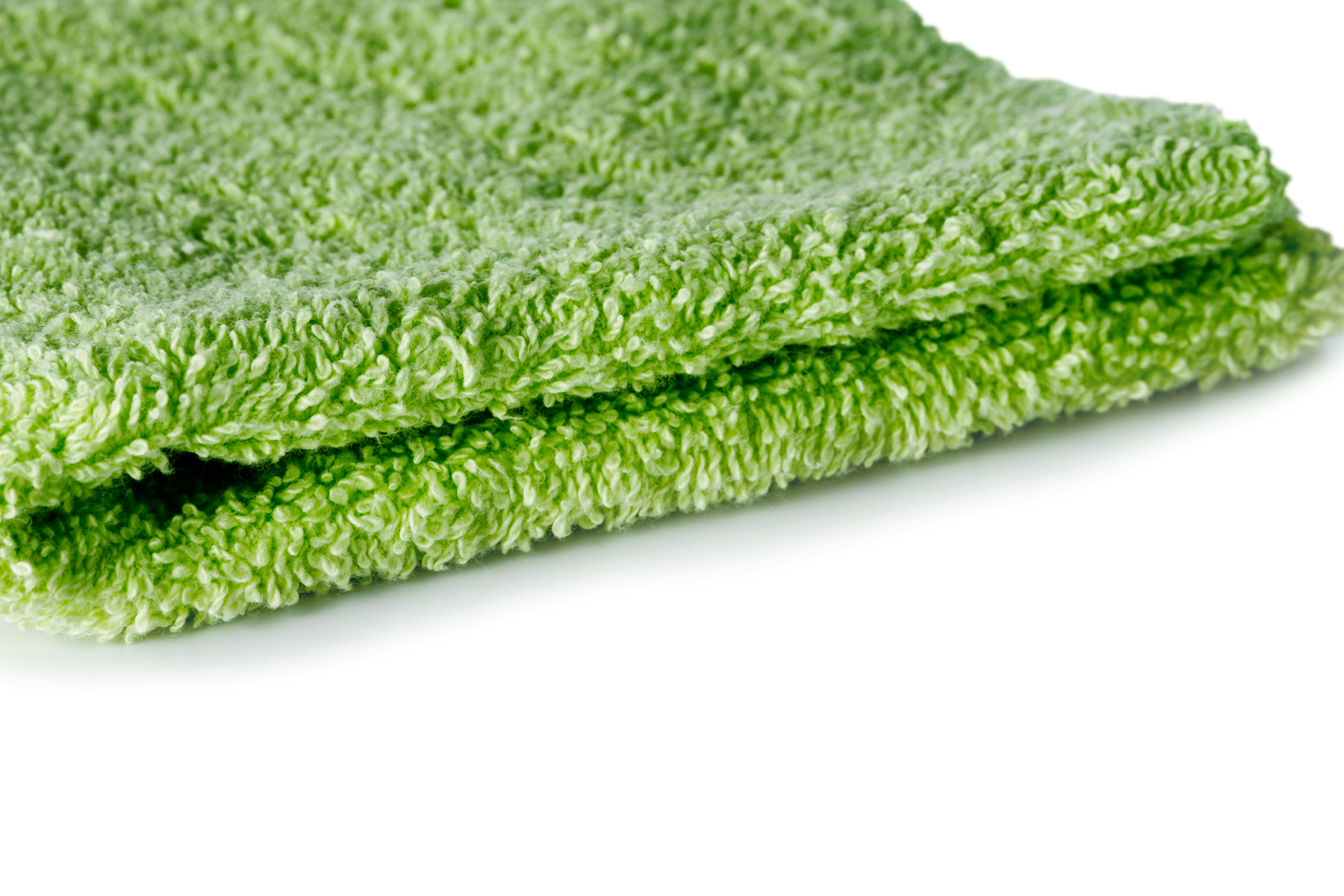 A close up of a green towel on a white background