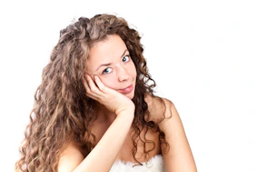 A woman with curly hair posing for a picture