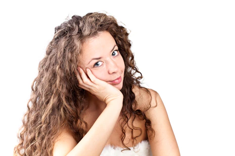 A woman with curly hair posing for a picture