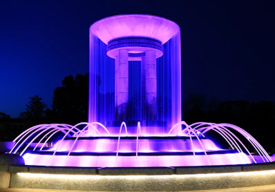A water fountain lit up with purple lights