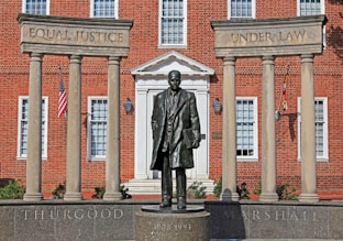 A statue of a man standing in front of a building