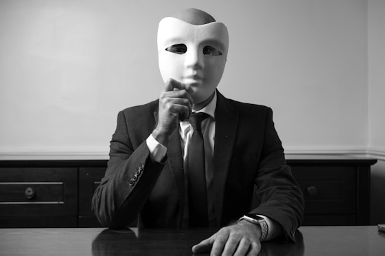 A man sitting at a table with a mask on his face