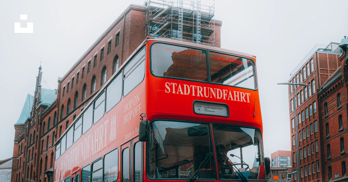 A red double decker bus driving down a street photo – Free Hamburg ...