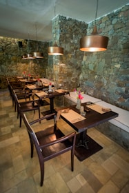 A restaurant with a stone wall and wooden tables