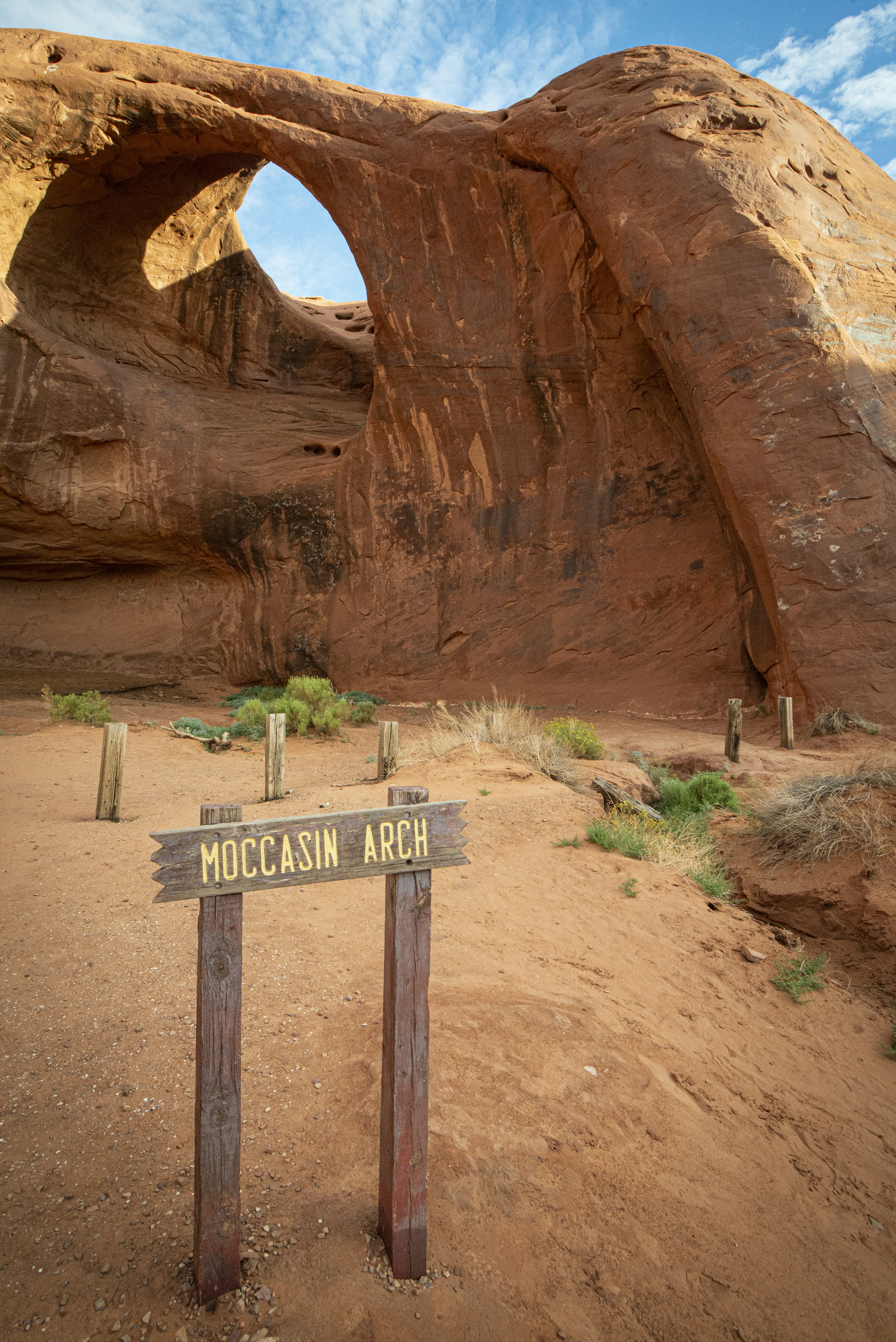 A sign in front of a large rock formation