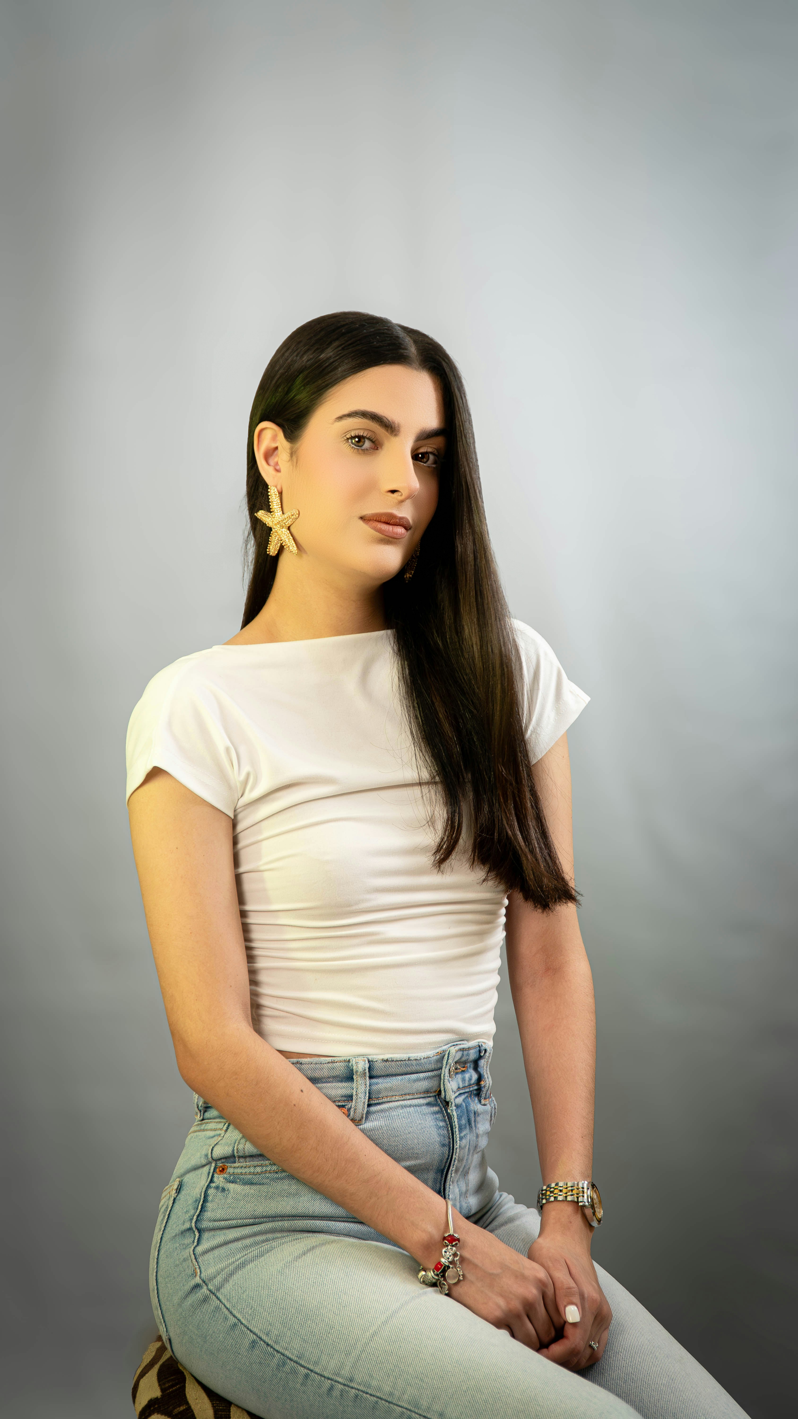 Una mujer sentada en un taburete con las piernas cruzadas