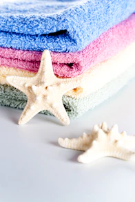 A stack of towels and a starfish on a table