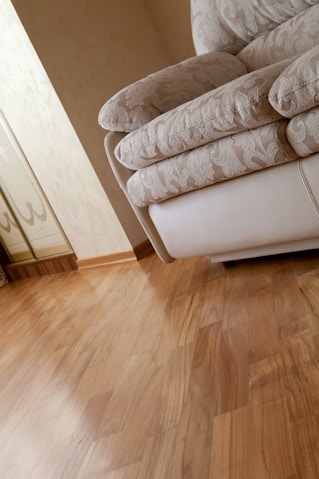 A white couch sitting on top of a hard wood floor