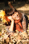 A woman laying on top of a pile of leaves