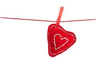 A red heart hanging on a clothes line