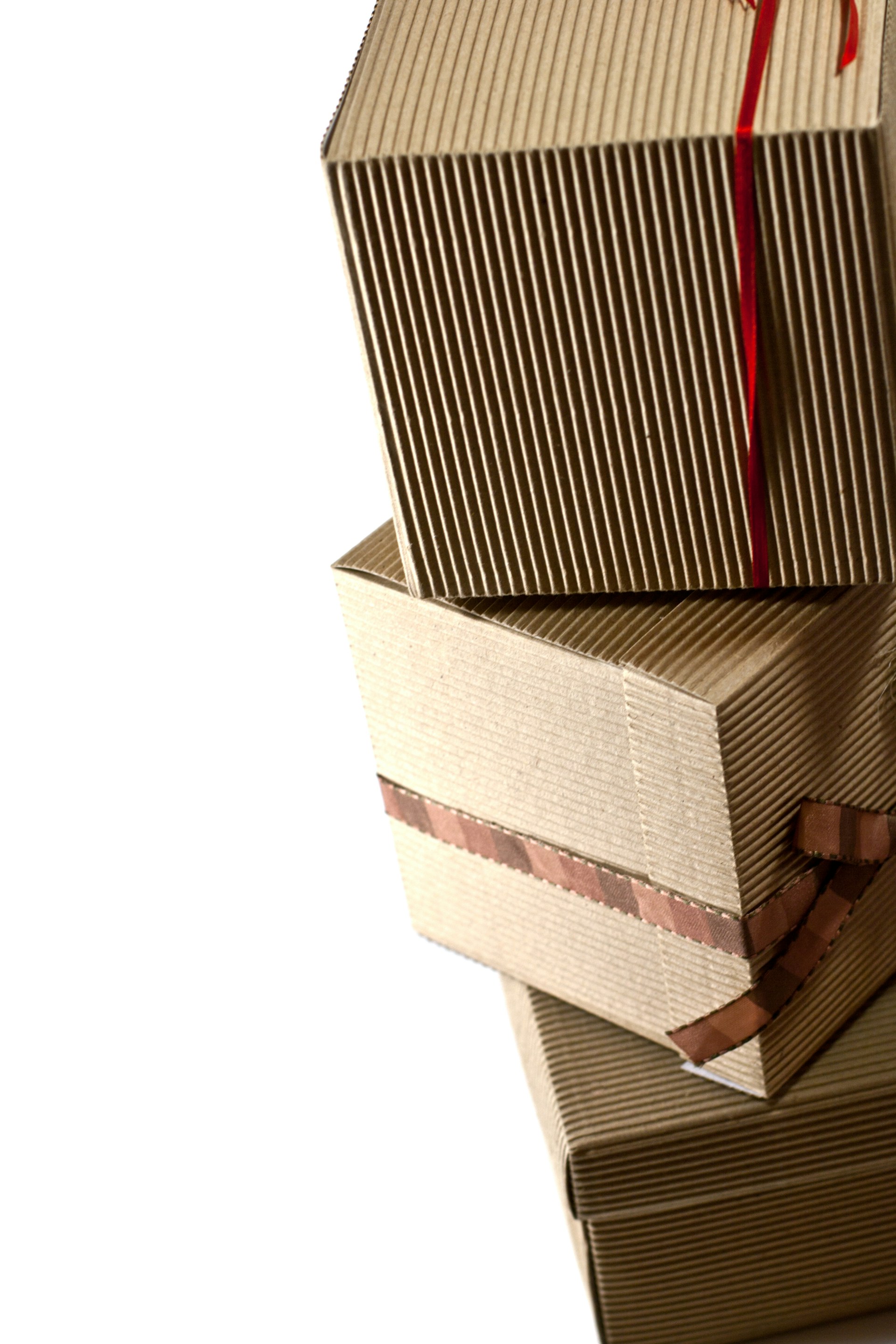 A stack of three wrapped gift boxes with a red ribbon