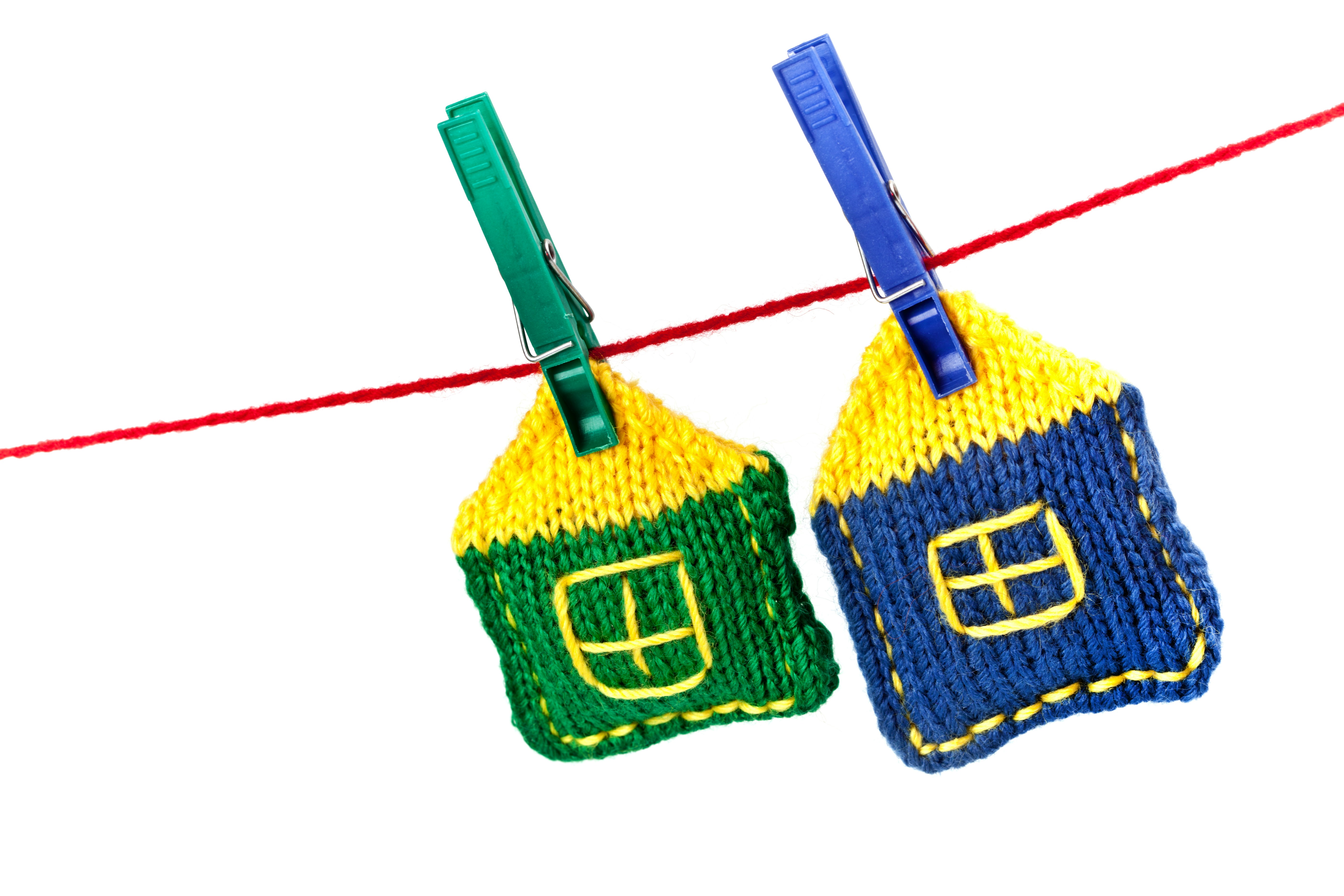 Two knitted house shapes pegged on a clothesline