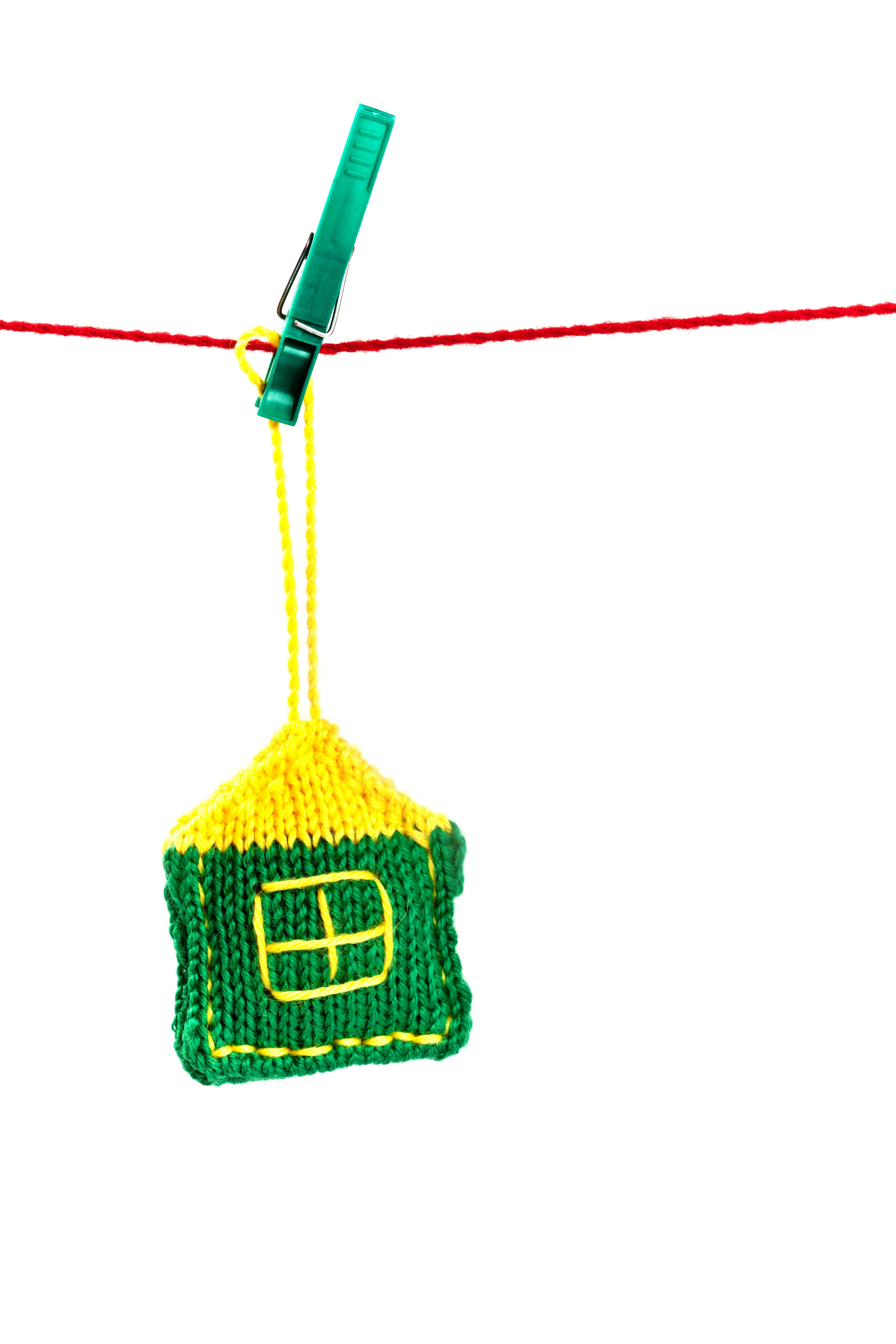 A green and yellow hat hanging from a clothes line