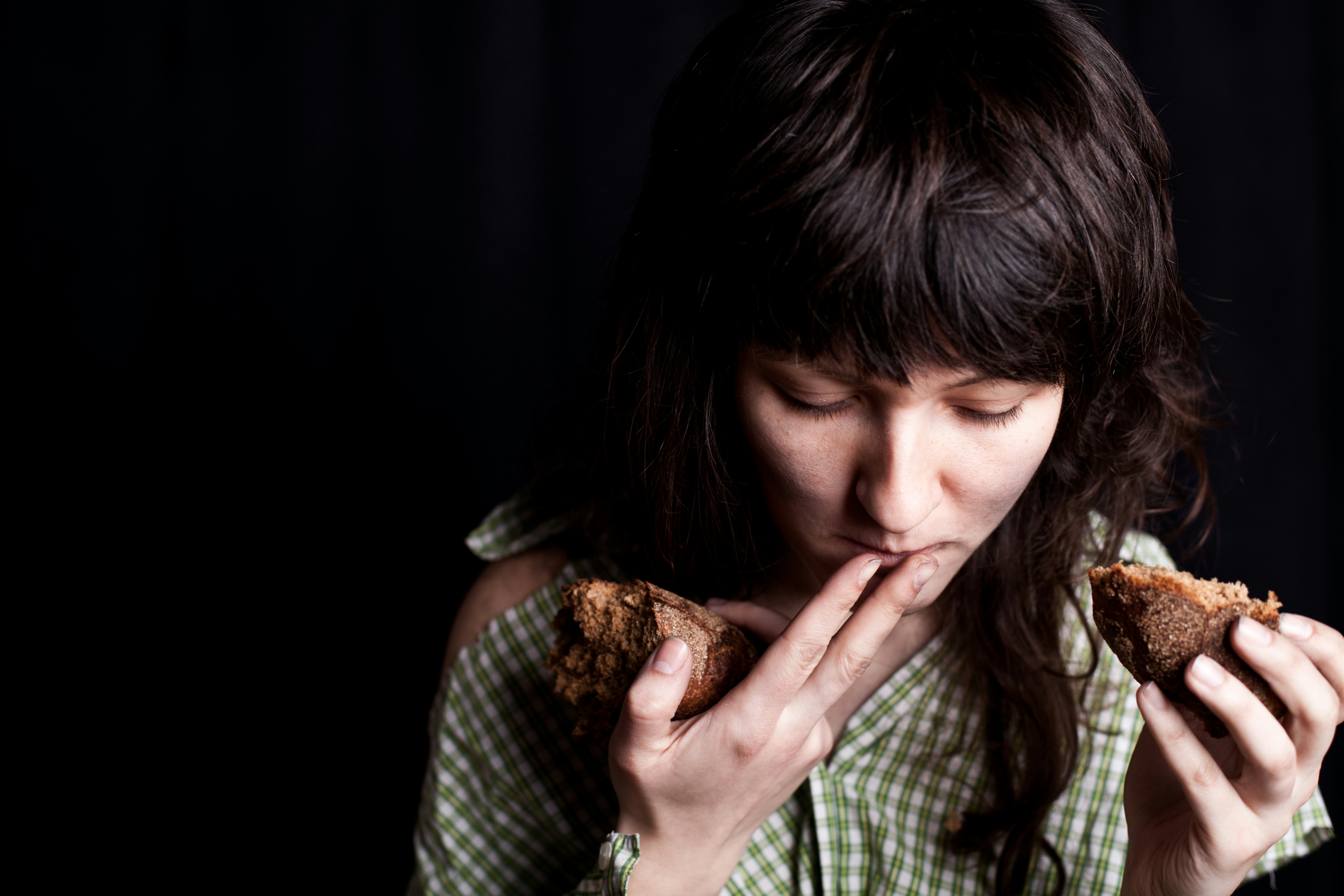 A woman is eating a piece of food