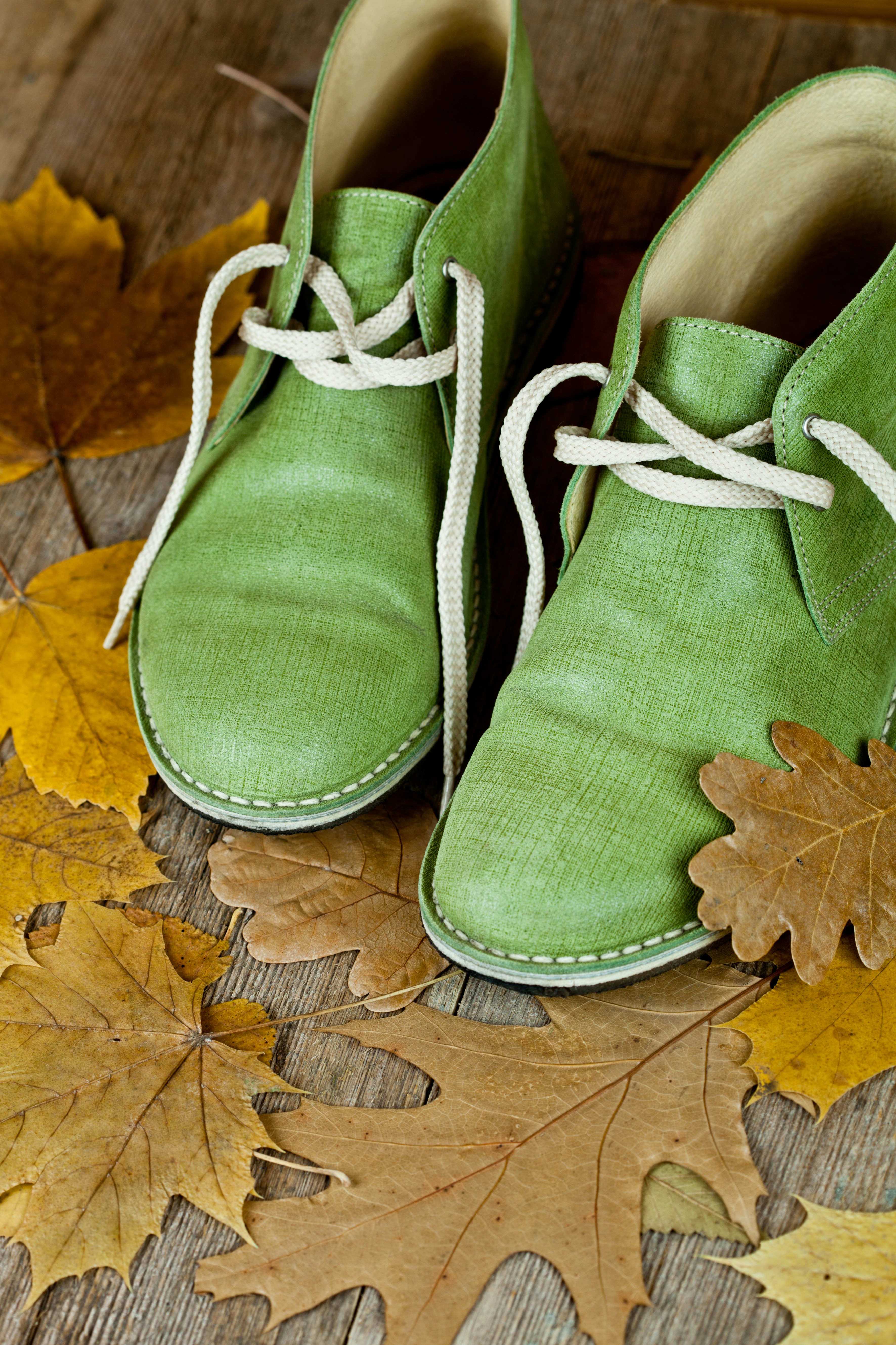 A pair of green shoes sitting on top of a wooden floor