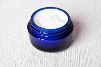 A jar of cream sitting on top of a white table