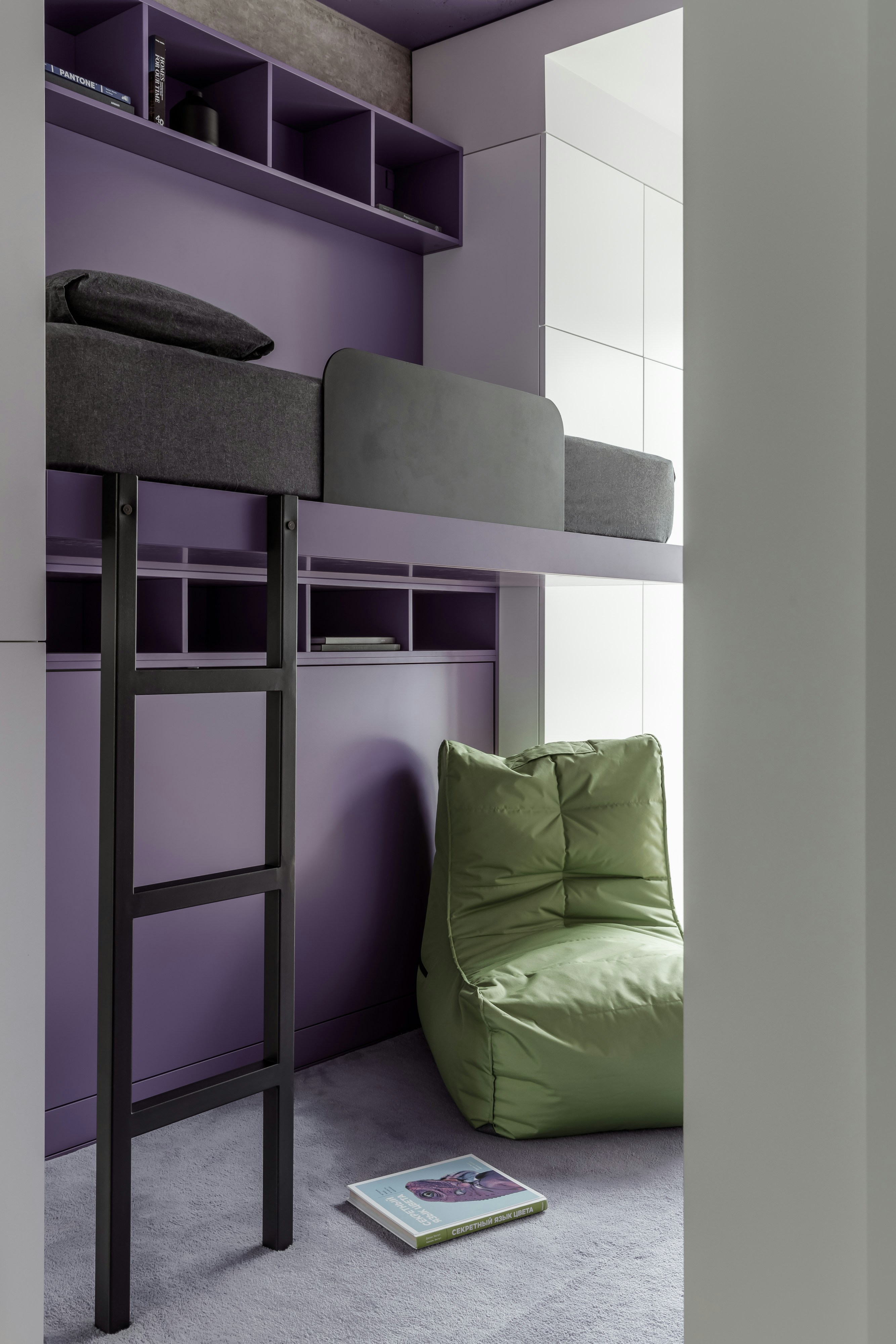 A room with a bunk bed and a green chair