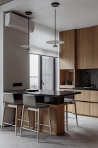 A kitchen with a table a stools and a window