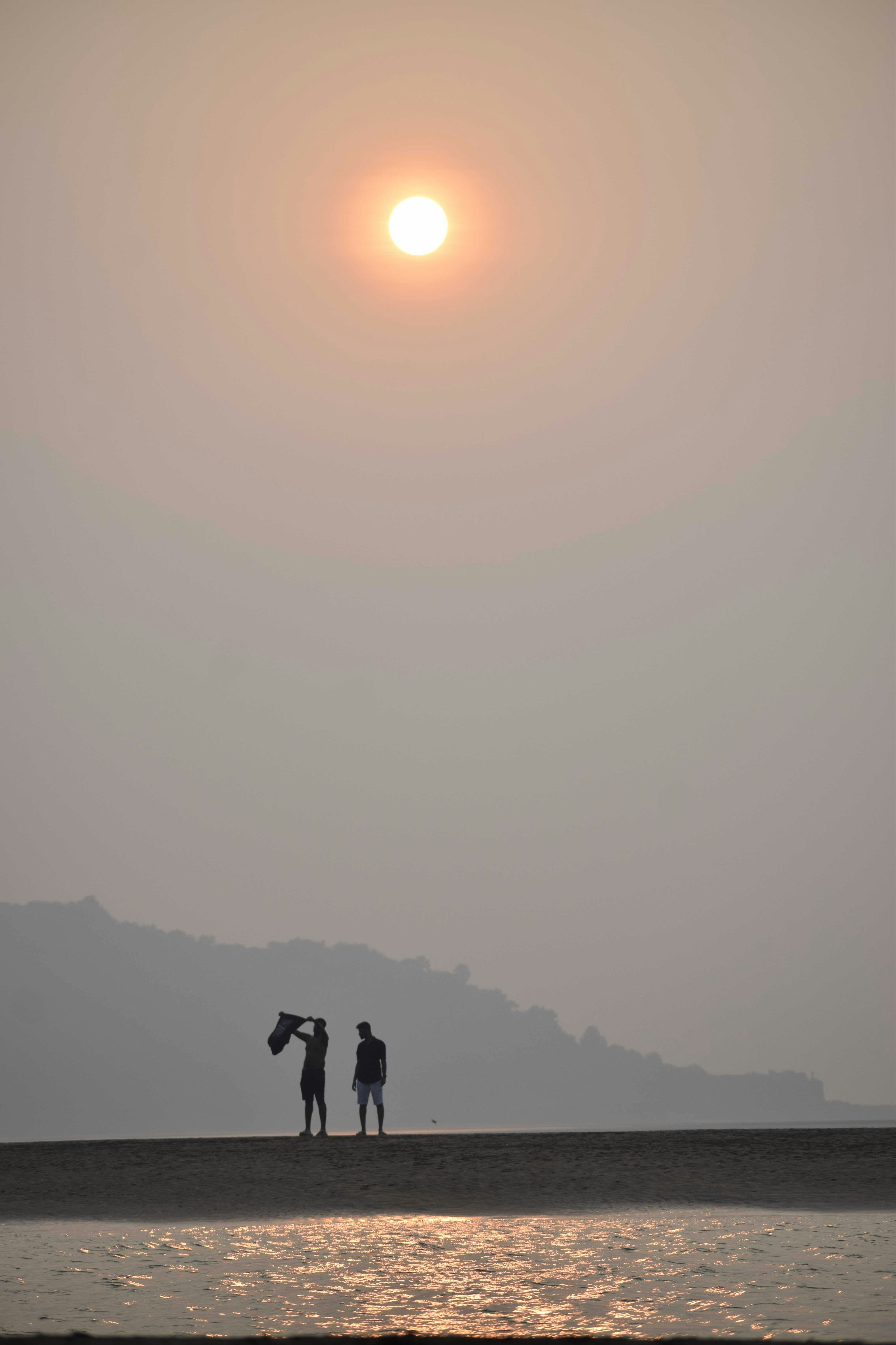 A couple of people standing on top of a beach