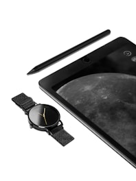An image of a tablet with a watch and pen