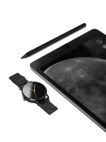 An image of a tablet with a watch and pen