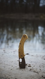 A yellow and black object sitting on top of a sandy beach