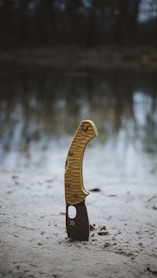 A yellow and black object sitting on top of a sandy beach