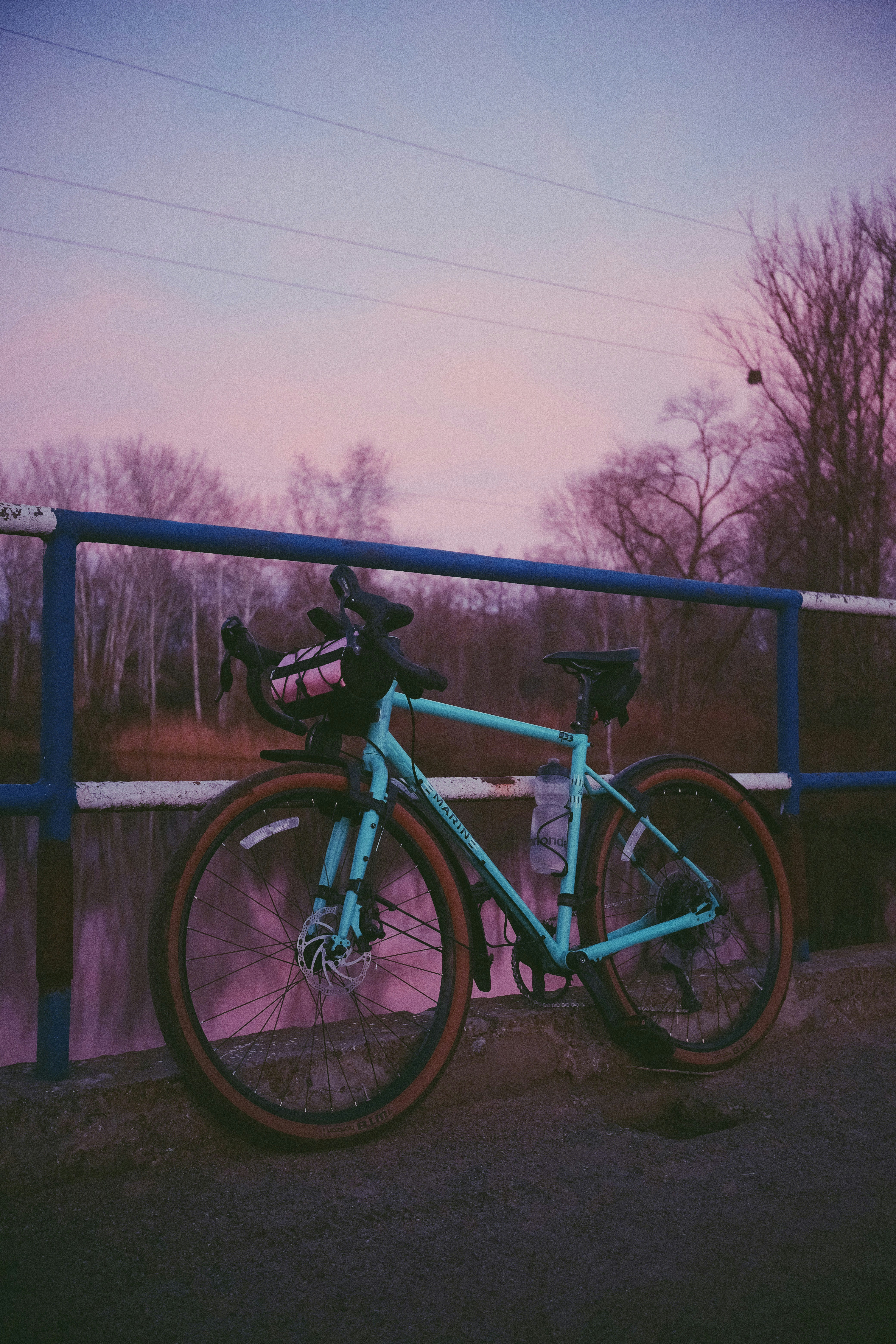 A blue bicycle parked next to a blue fence