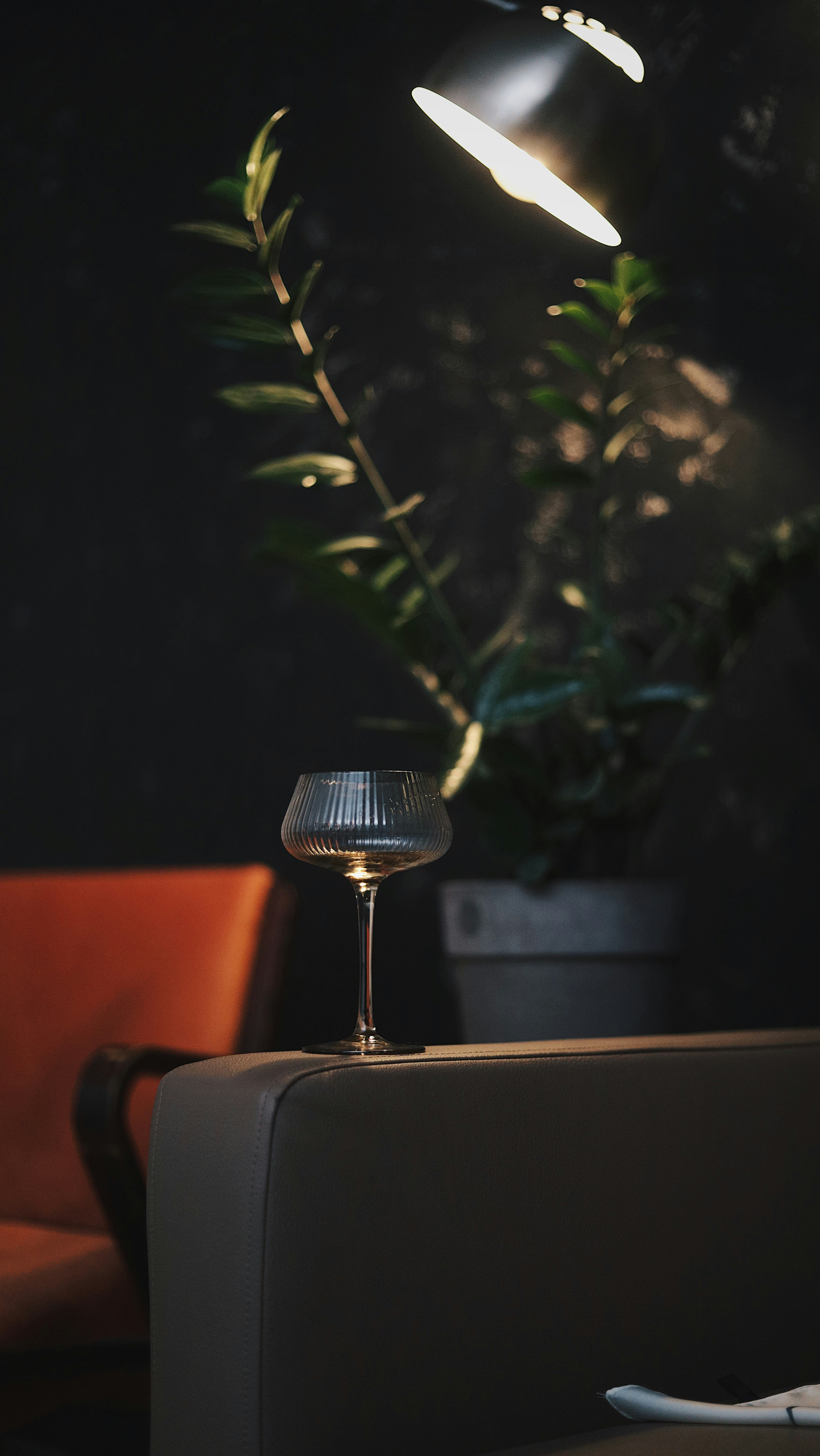 A room with a couch and a table with a lamp on it