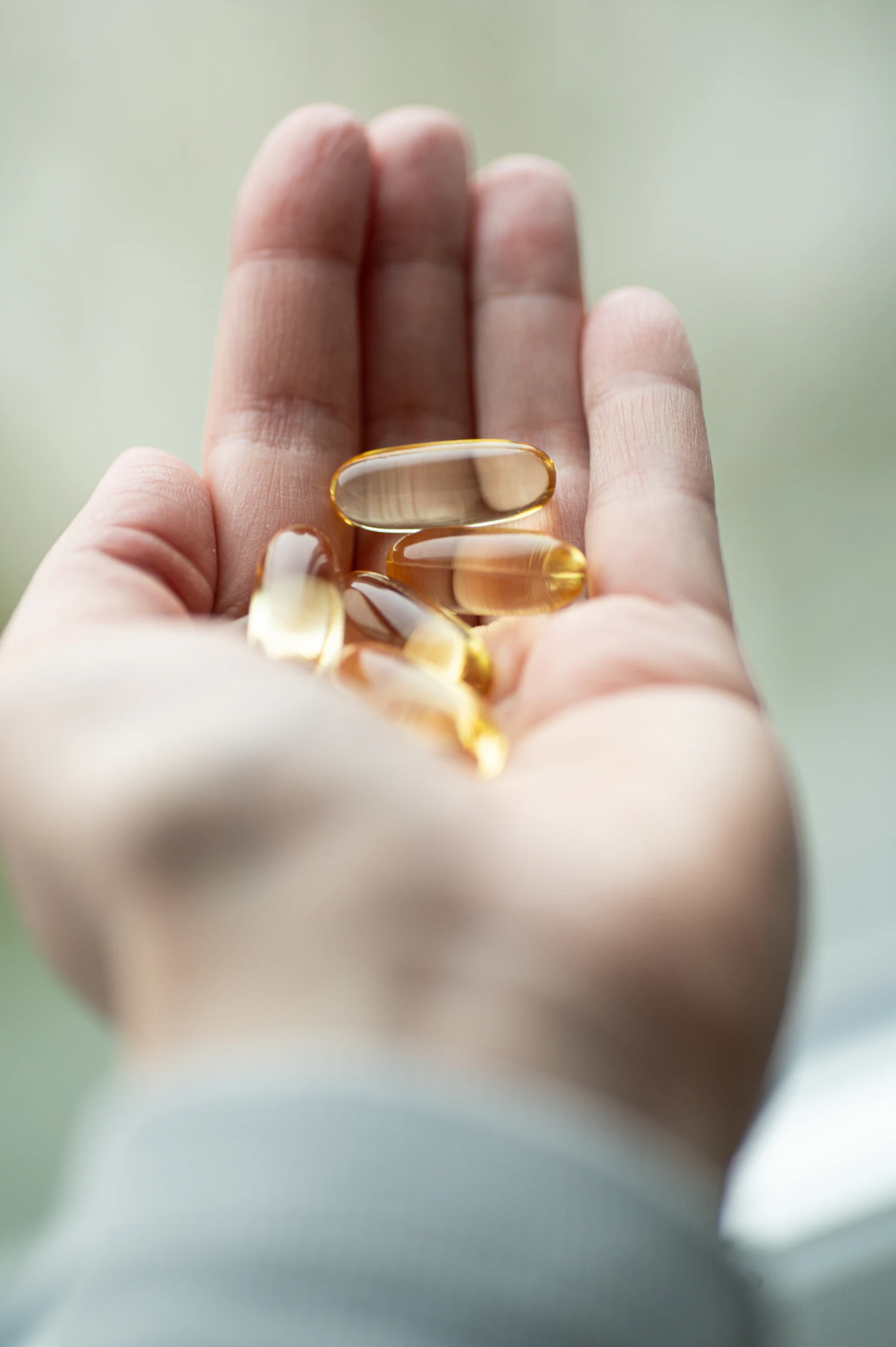 A handful of softgels in an open palm