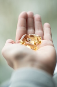 A person holding two pills in their palm