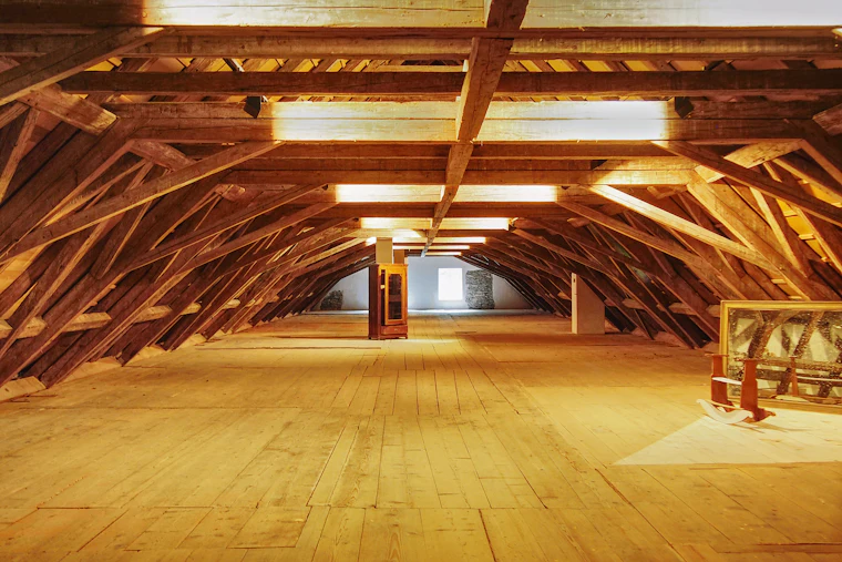 Large open interior space with exposed wood beams and flooring