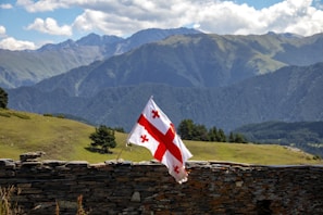 A flag flying on top of a stone wall