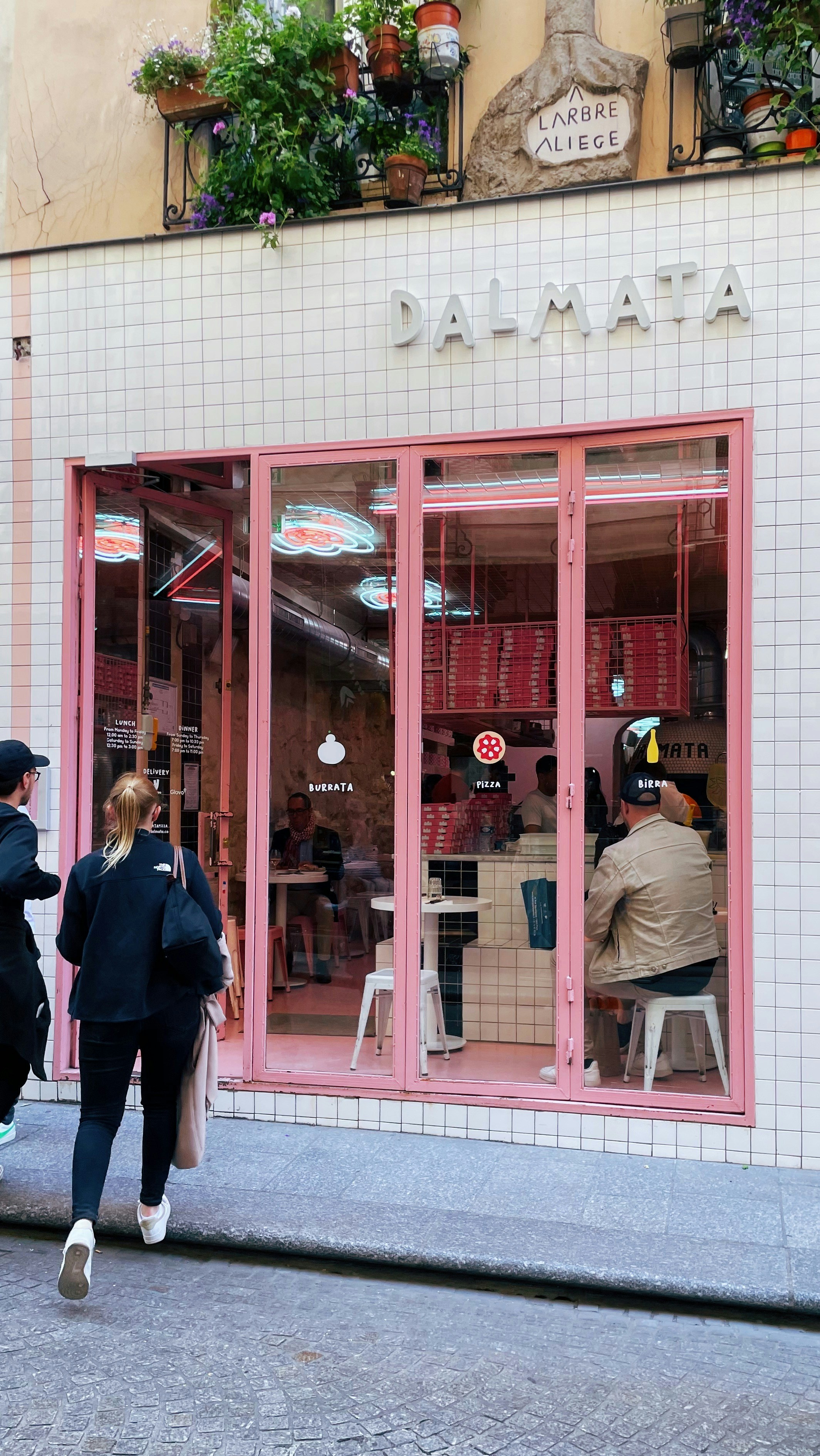 A group of people walking past a store front