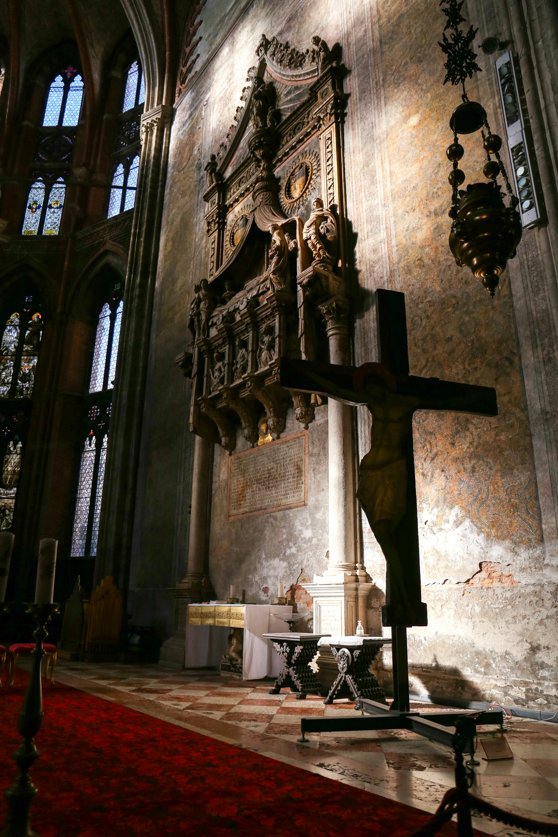 A cross in a church with a red carpet