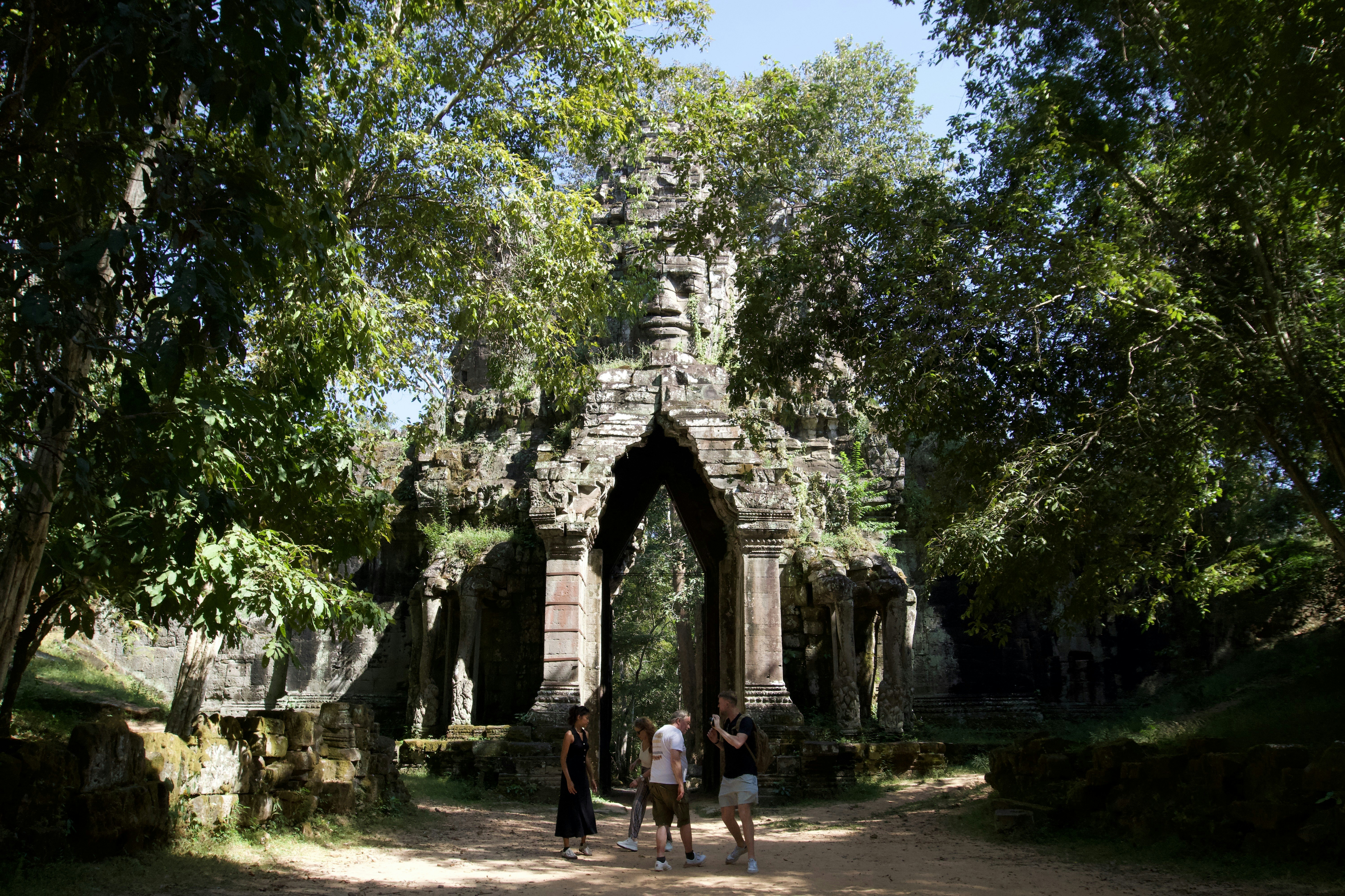A group of people walking down a dirt road