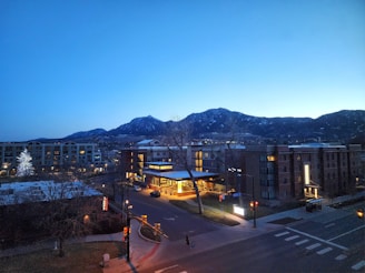 A view of a city at night with mountains in the background