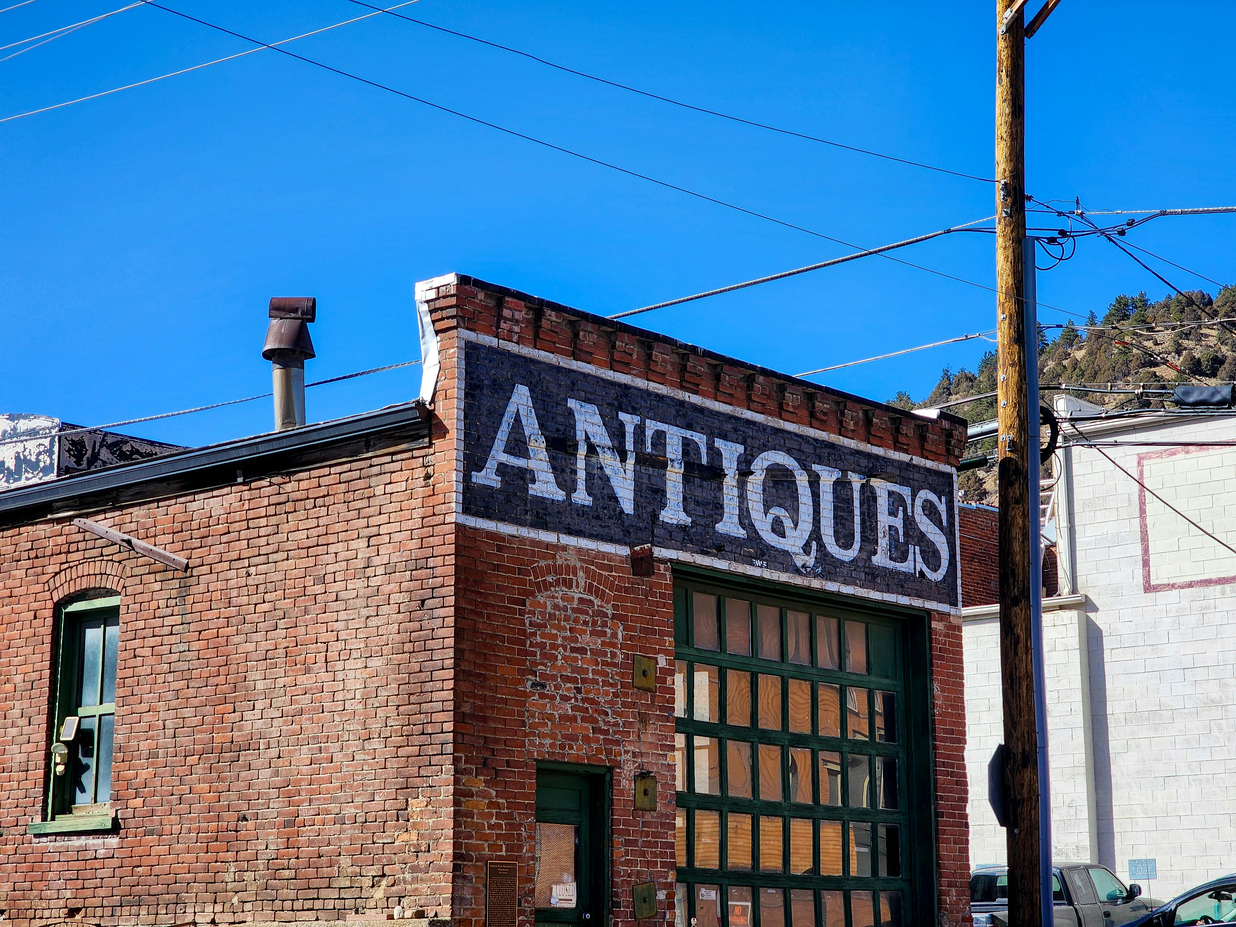 An old brick building with a sign that says antiques